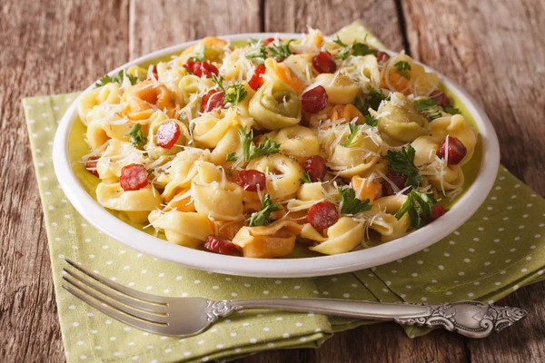 Pyszne gorące kolorowe tortellini z parmezanem i pokrojona w plastry sausag — Zdjęcie stockowe