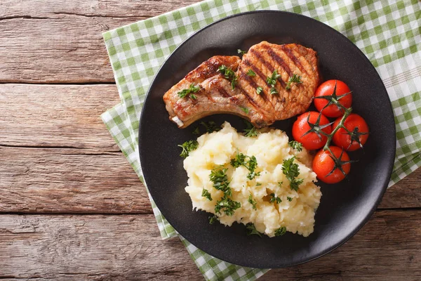 Grilled pork loin with mashed potatoes and tomato close-up. Hori — Stock Photo, Image