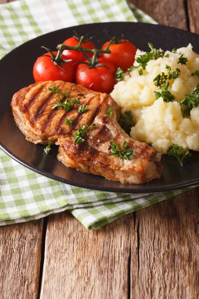 Lombo de porco grelhado com purê de batatas e tomate close-up. Vert. — Fotografia de Stock