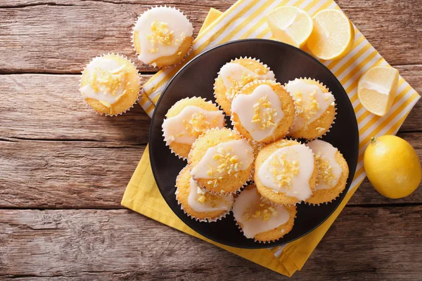 Magdalenas de limón caseras espolvoreadas con ralladura de cerca en un plato . — Foto de Stock