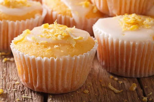 Delicious lemon muffins with icing and zest macro. Horizontal — Stock Photo, Image