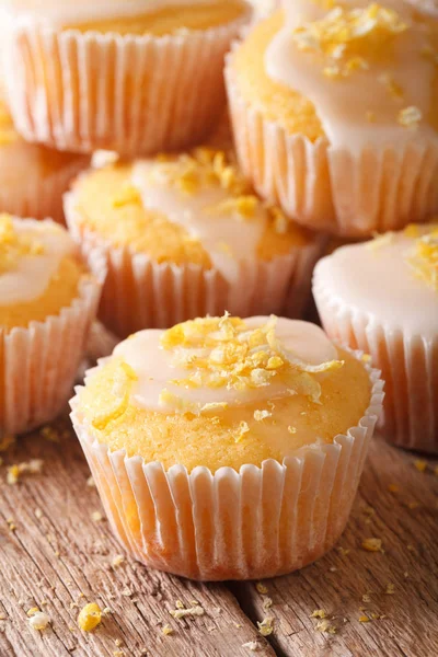 Leckere Zitronenmuffins mit Zuckerguss und Schale Makro. vertikal — Stockfoto