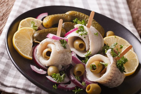 Rolls of marinated herring with olives, onions, pickles and lemo — Stock Photo, Image