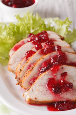 Kavrulmuş hindi göğsü kızılcık sosu yakın çekim ile dilimlenmiş. Vert