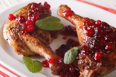 roasted duck leg with cranberry sauce and mint closeup. horizont clipart