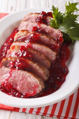 Kızarmış ördek göğsü kızılcık sosu yakın çekim ile dilimlenmiş. Dikey