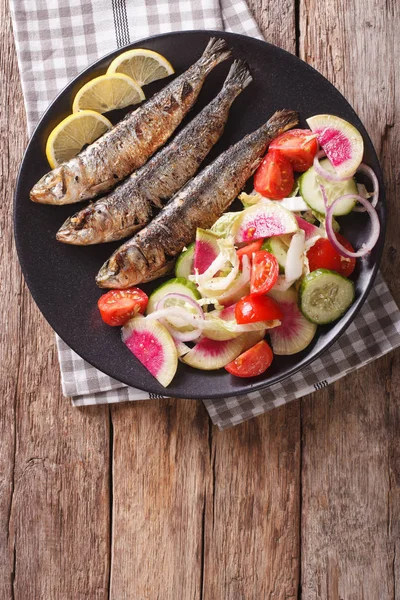 Grilled sardines with fresh vegetable salad close-up. vertical t — Stock Photo, Image