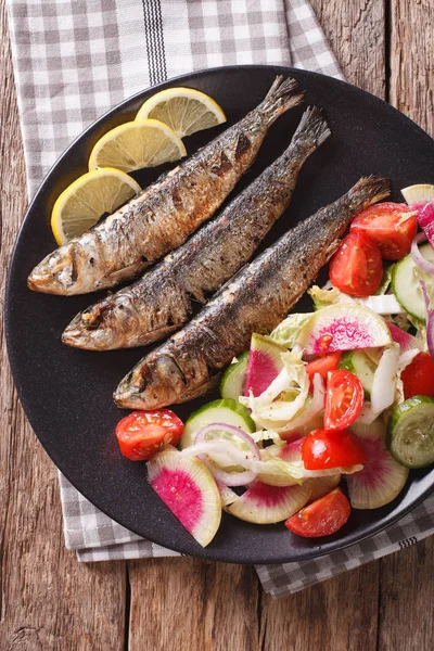Grillade sardiner med sallad på gurka, rädisor, tomat, lök — Stockfoto