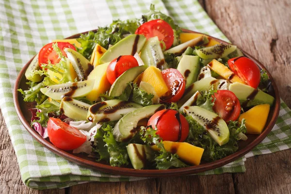 Sabrosa ensalada de mango, aguacate, kiwi, lechuga, tomate de cerca — Foto de Stock