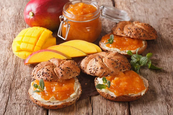 Bollos con mermelada de mango, mantequilla y decorado con menta cerca — Foto de Stock