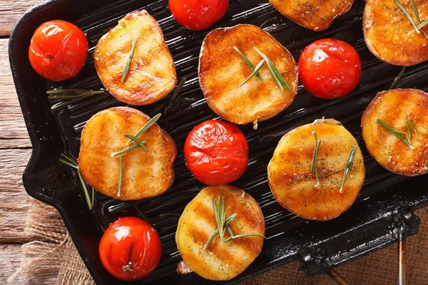 Las patatas asadas y los tomates con el romero se acercan a la parrilla —  Fotos de Stock