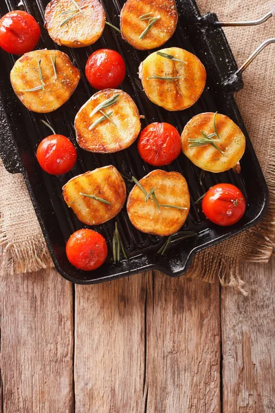 Lekker geroosterde aardappelen en tomaten met rozemarijn close-up op een — Stockfoto