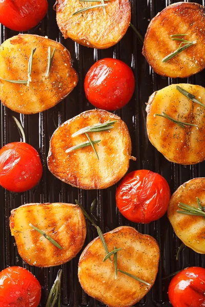 Batatas grelhadas e tomates com ervas perto em uma panela de grelha — Fotografia de Stock