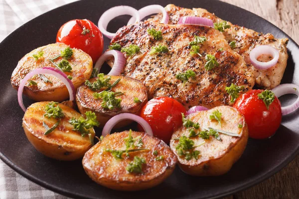 Chicken meat grilled with new potatoes and tomatoes close-up. ho — Stock Photo, Image