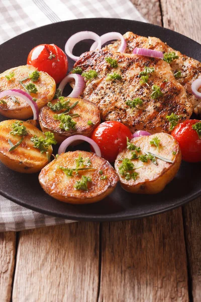 Gustosa bistecca di pollo con patate novelle alla griglia e pomodori chiudi — Foto Stock