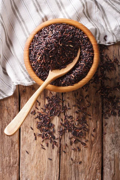 Zdrowe dzikiego ryżu długi czarny z bliska w drewniane miski i łyżka — Zdjęcie stockowe
