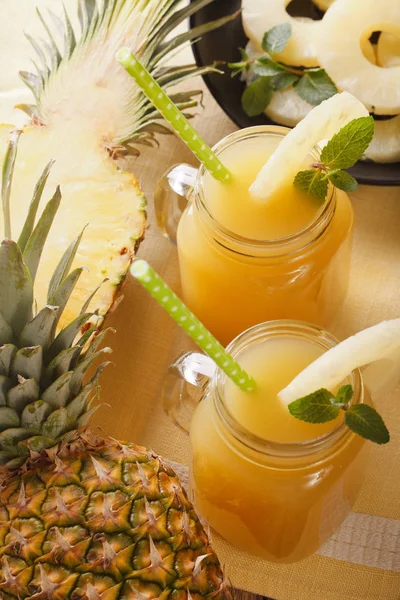 Delicious fresh pineapple juice in a glass jar closeup. vertical — Stock Photo, Image