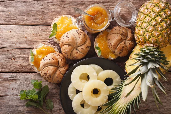 Zelfgemaakte ananas jam en zoete broodjes op een tafel. horizontale boven — Stockfoto