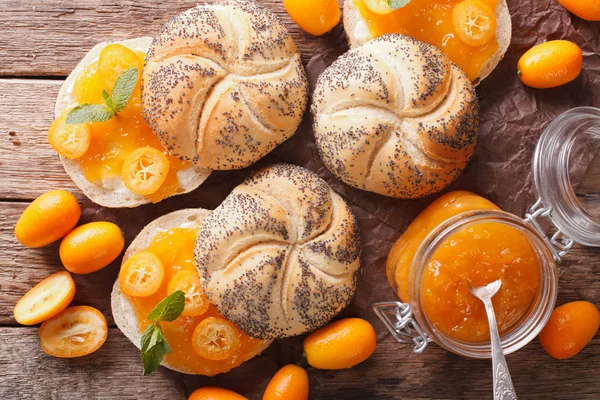 Kumquat jam in een glazen pot en zoete broodjes close-up op de — Stockfoto
