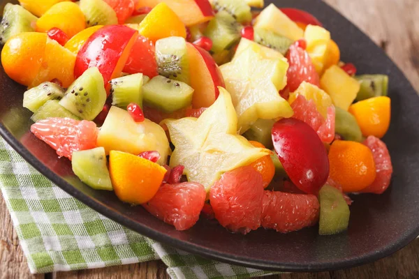Salade de fruits exotiques en gros plan sur une assiette. horizontal — Photo