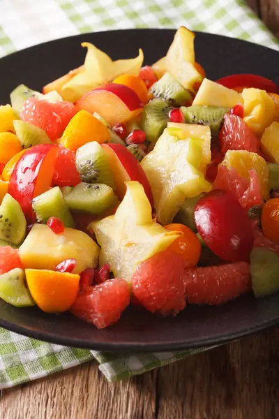 Salad of fresh tropical fruits close-up on a plate. vertical — Stock Photo, Image