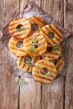 Masanın üzerine nane ile taze ananas yüzük kızarmış. Dikey üst