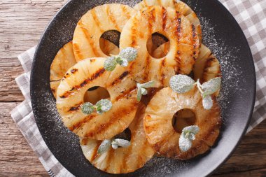 Nane ile lezzetli ızgara ananas bir plaka üzerine kapatın. Yatay