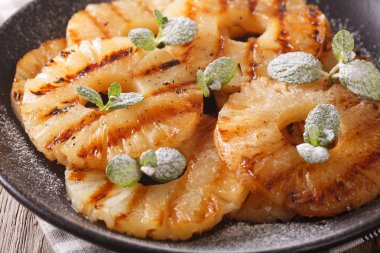 Izgara ananas ile pudra şekeri ve nane makro. Yatay