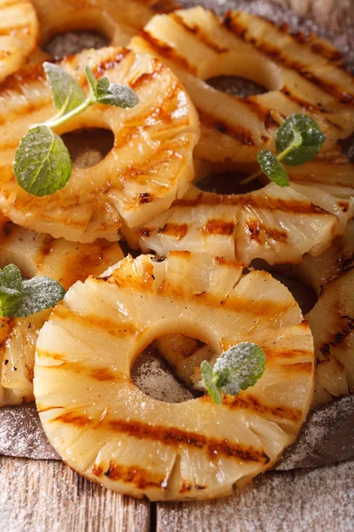 Gegrillte Ananas mit Minze und Puderzucker in Nahaufnahme auf dem Teller — Stockfoto