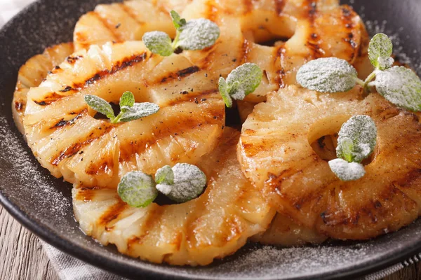 Izgara ananas ile pudra şekeri ve nane makro. Yatay