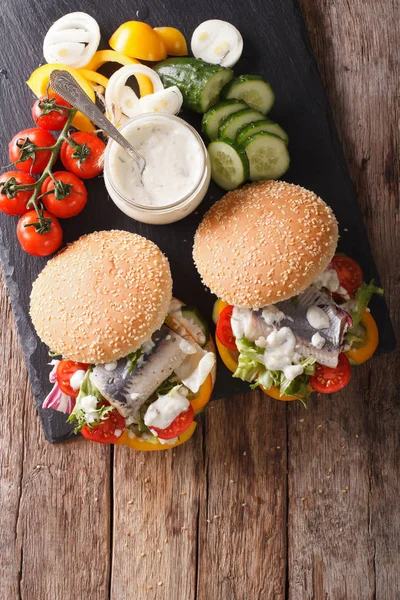 Fishburger com arenque, molho e legumes frescos close-up. ve — Fotografia de Stock