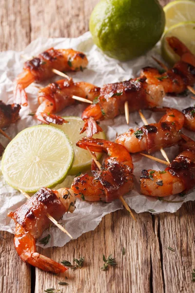 Tiger prawns wrapped in bacon on skewers with thyme and lime clo — Stock Photo, Image