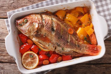 Tilapia ile sebze pişmiş ve kekik yakın çekim pişirme çanağı.