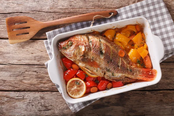 Tilapia fish baked with bell peppers, carrots and thyme close up — Stock Photo, Image