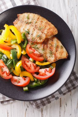 Izgara tilapia fileto ve taze sebze salatası yakın çekim. Vert