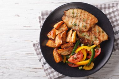 Izgara Tilapia filetosu ve patates dilimleri, taze salata yakın çekim. 