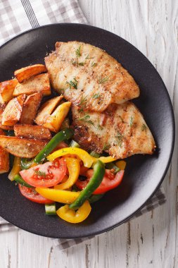 Izgara tilapia fileto, kızarmış patates ve sebze salatası clo