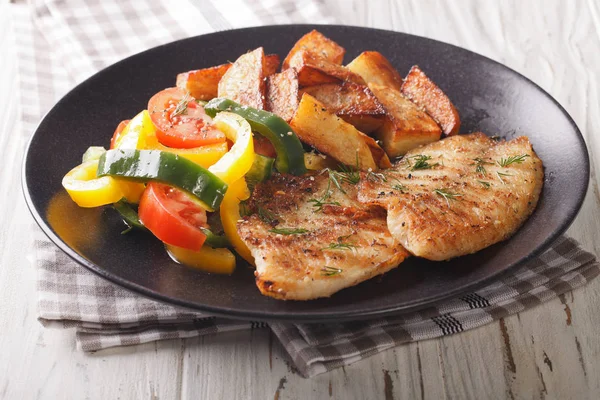 Grilled tilapia fillet, fried potatoes and a vegetable salad clo — Stock Photo, Image