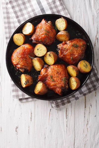 Roast chicken thighs and baby potatoes with maple syrup closeup. — Stock Photo, Image