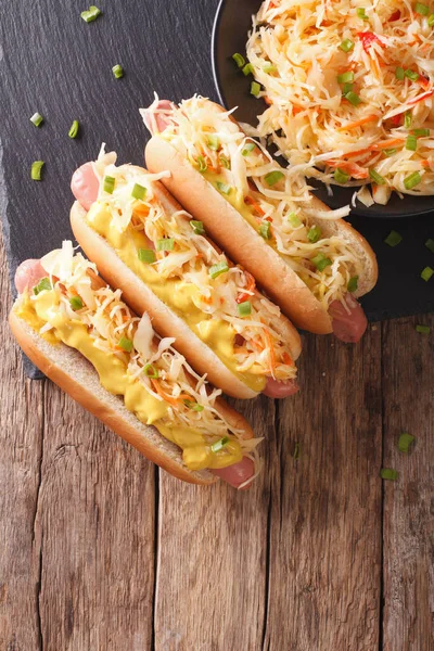 Hot dog with sauerkraut and mustard close up. Vertical top view — Stock Photo, Image
