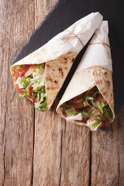 Burritos with bacon and fresh mix of salad close-up. Vertical to — Stock Photo, Image