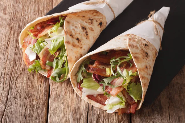 Fried bacon and salad wrapped in pita bread close-up. horizontal — Stock Photo, Image