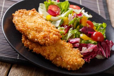 Tavuk pirzola pane ve taze bir salata yakın çekim karışımı içinde. hor