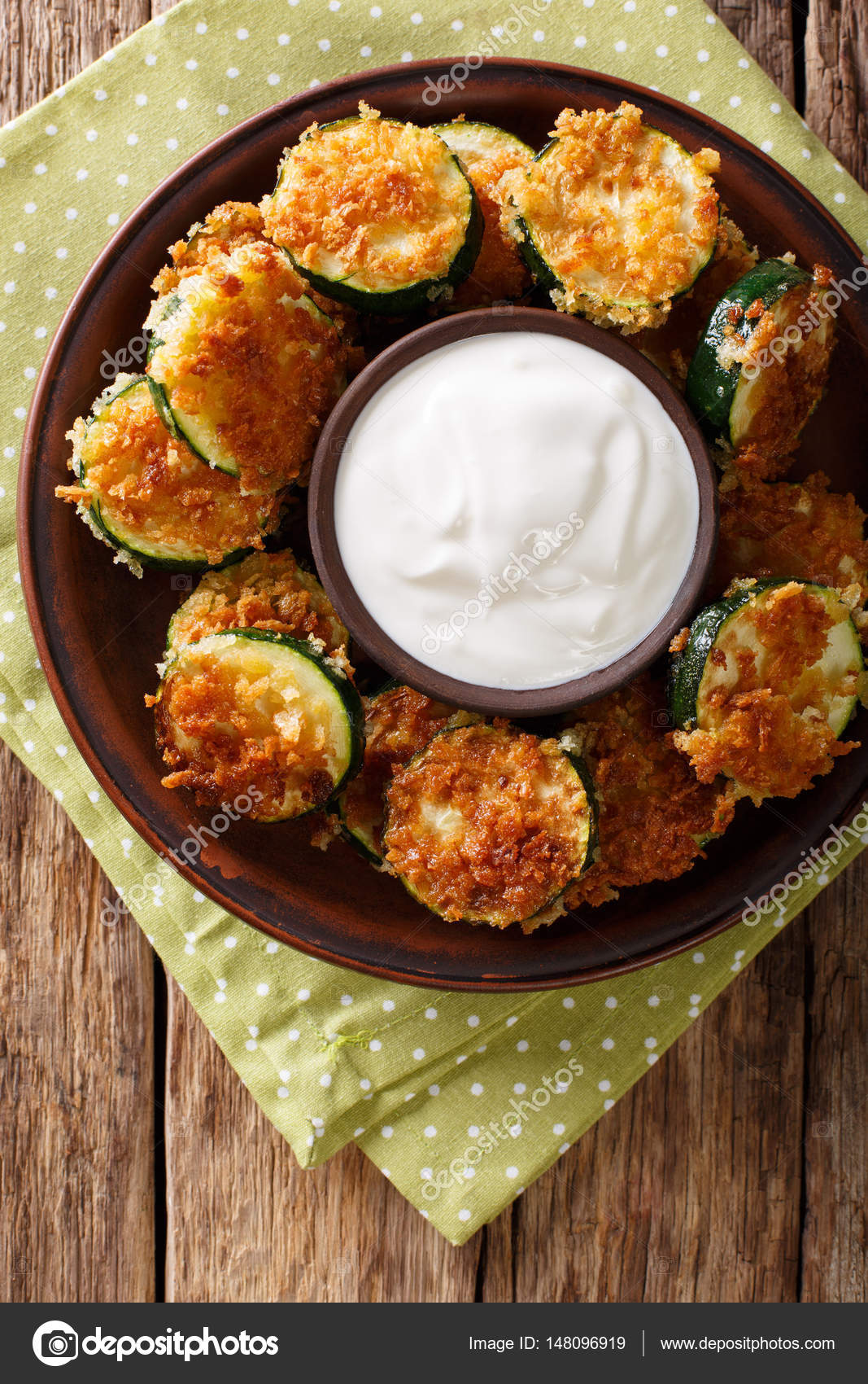 Fried zucchini slices in breaded Panko with sour cream closeup