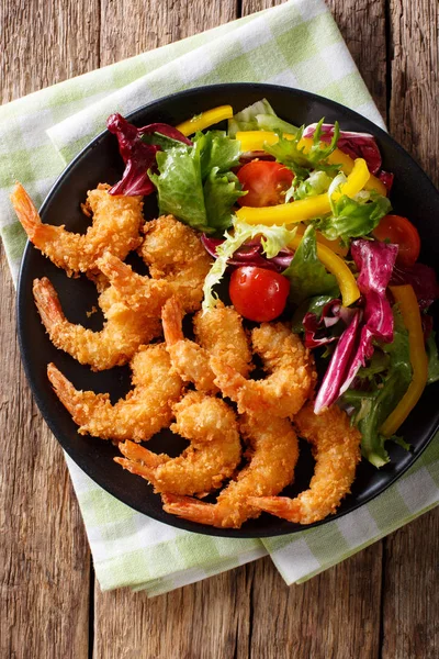 Shrimp in a breaded and salad of fresh vegetables close-up on a — Stock Photo, Image