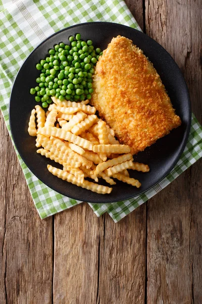 Traditional British food: Fish and chips with green peas close-u