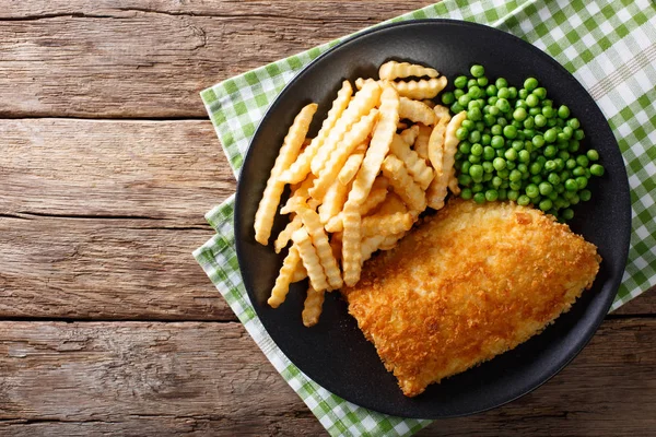 Comida tradicional britânica: Peixe e batatas fritas com ervilhas verdes close-u — Fotografia de Stock