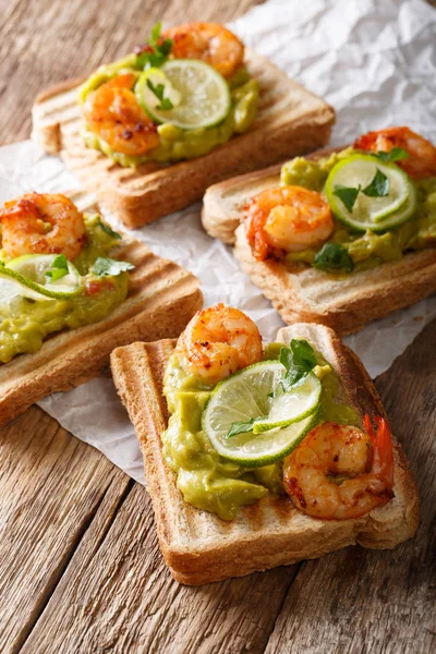 Tasty toast with guacamole, prawns and lime close-up. vertical — Stock Photo, Image