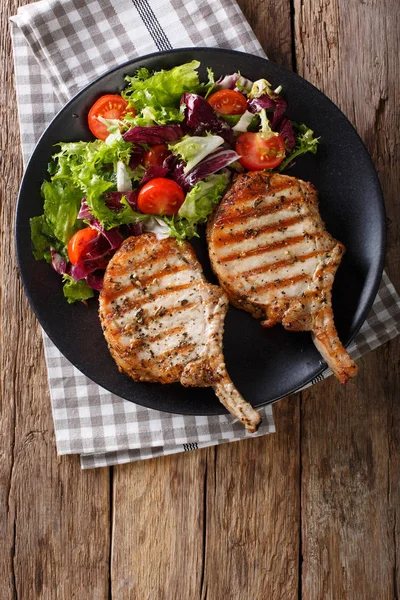 Costeleta de porco picante churrasco com salada mista em um close-up prato. Vert. — Fotografia de Stock