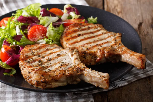 Grilled spicy pork cutlet and fresh salad close-up on a plate. h — Stock Photo, Image